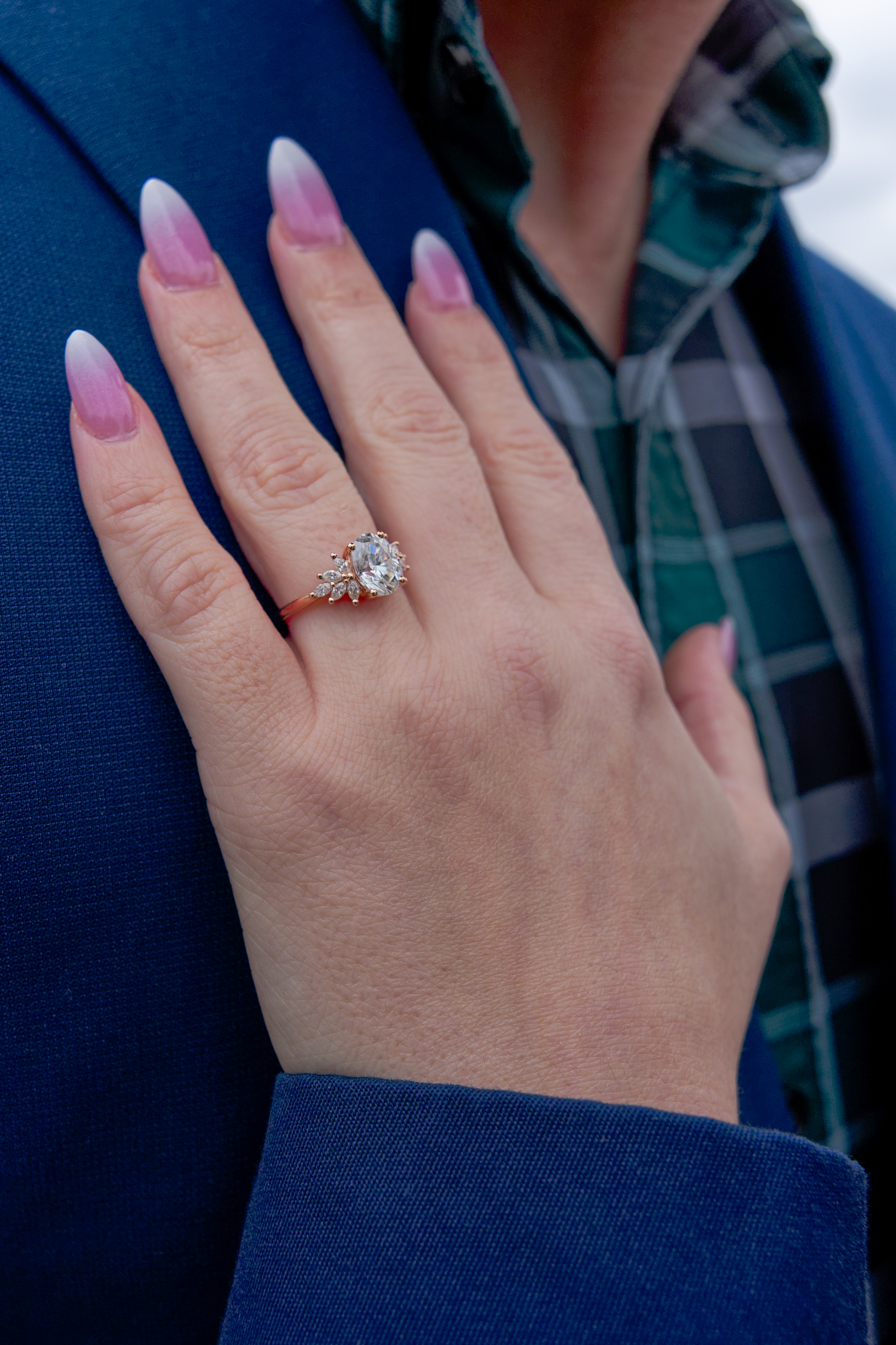 Her hand, newly ringed, resting on his navy lapel